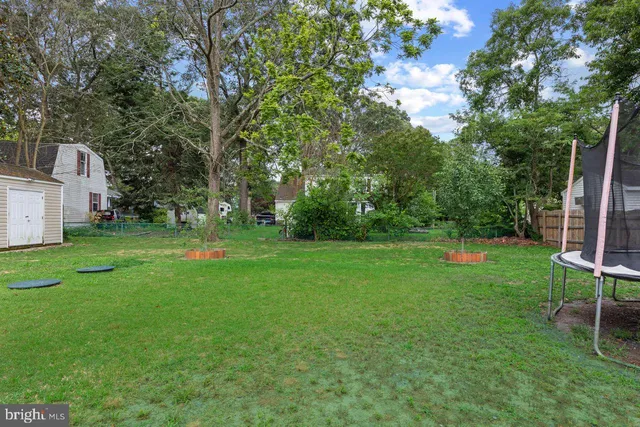 a view of a yard in front of a house with large trees