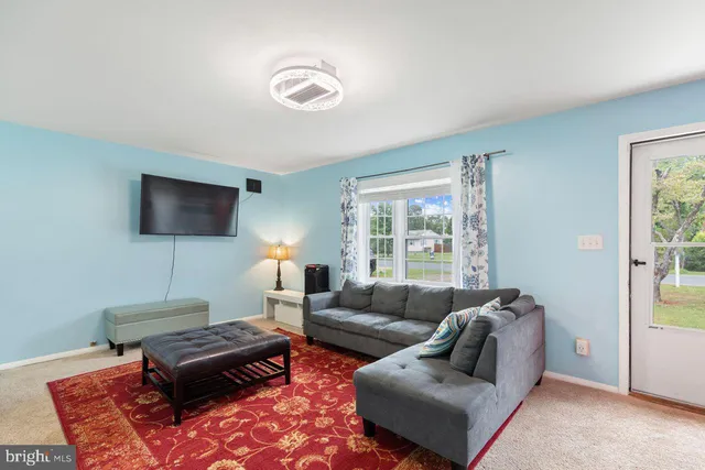 a living room with furniture a flat screen tv and a window