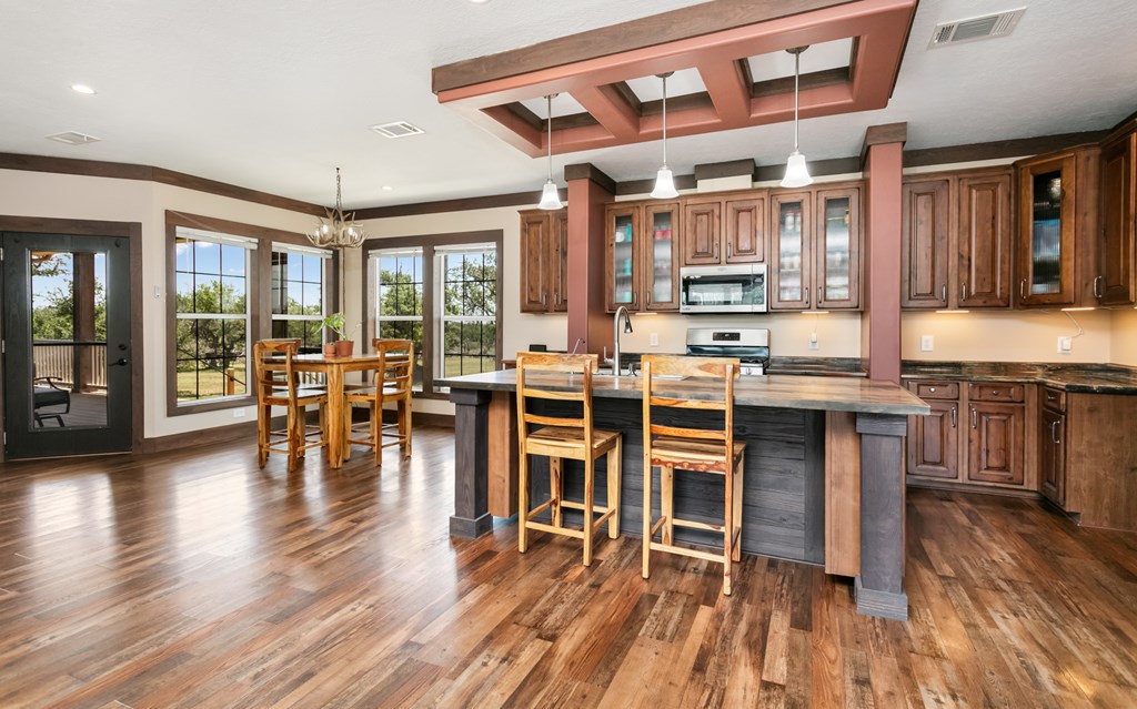 134 Concho Trail Harper, TX 78631 - Photo 4 of 31 a open kitchen with a table chairs and wooden floor
