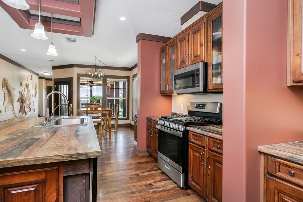 134 Concho Trail Harper, TX 78631 - Photo 9 of 31 a kitchen with granite countertop lots of counter top space and stainless steel appliances