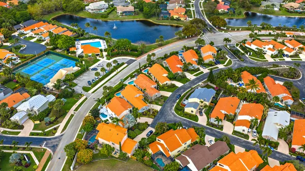 an aerial view of residential houses with outdoor space and ocean view
