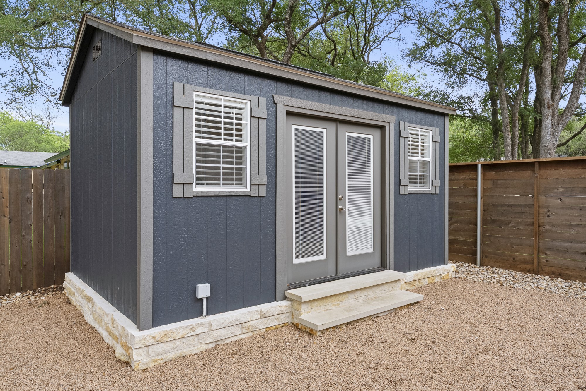 2802 Robin Road Manchaca, TX 78652 - Photo 29 of 40 Detached structure featuring board-and-batten siding, double-pane glass French doors, and decorative window shutters