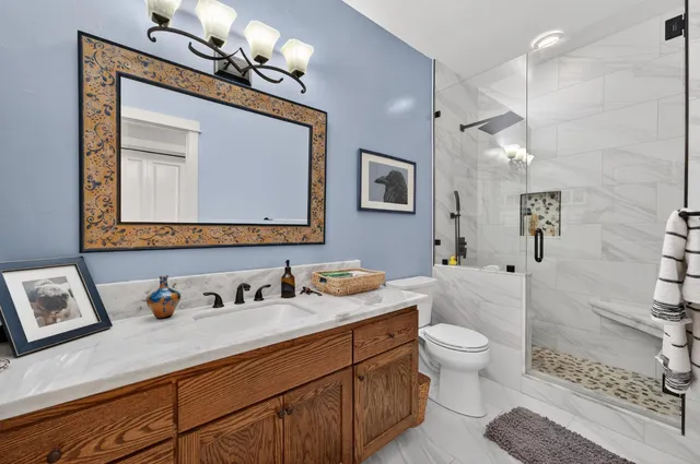 a bathroom with a granite countertop sink mirror vanity and toilet