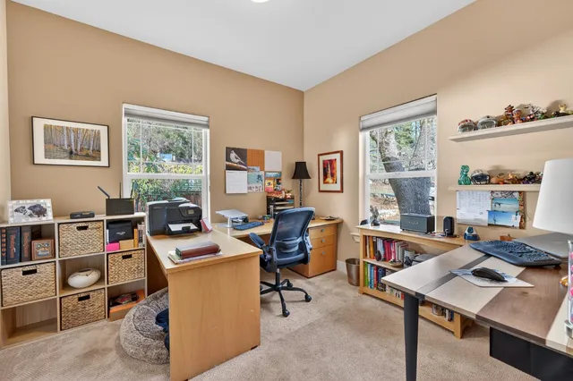 a view of a workspace with furniture and a window
