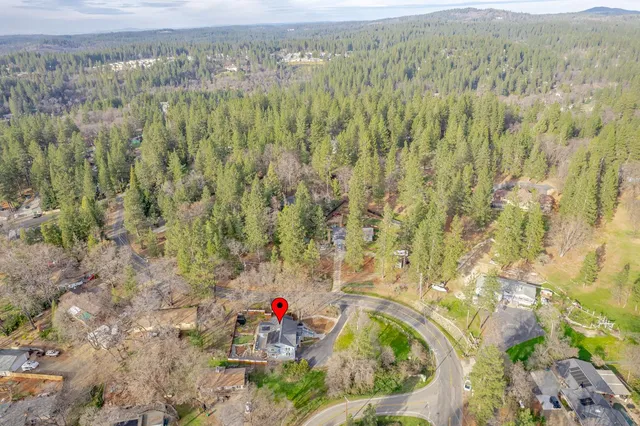 a aerial view of a houses with a yard and mountain