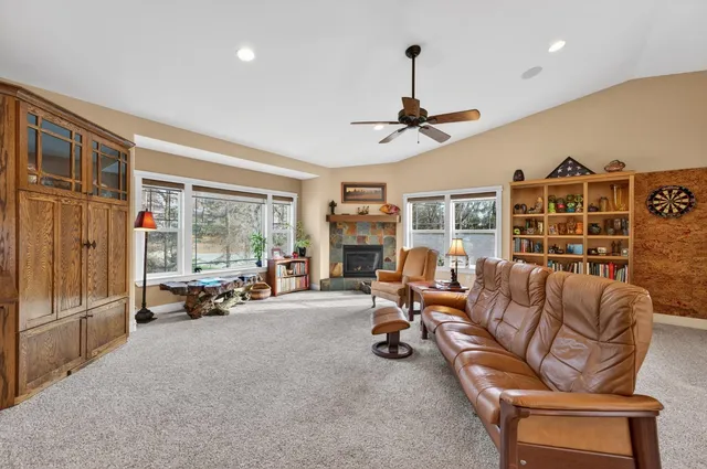 a view of a livingroom with furniture a fireplace window and outside view