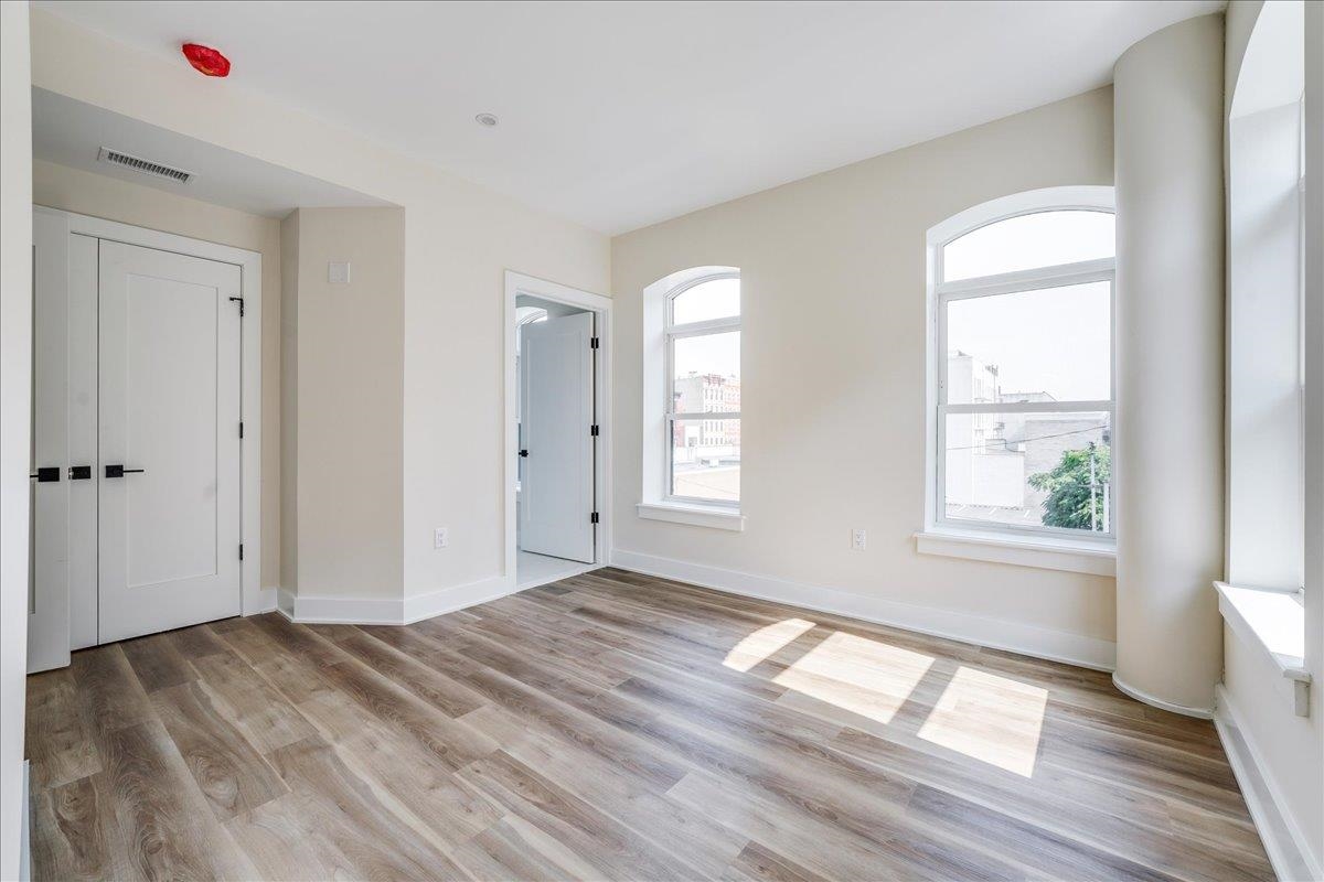 237 Washington Street, Unit 204 Hoboken, NJ 07030 - Photo 13 of 34 a view of empty room with wooden floor and fan