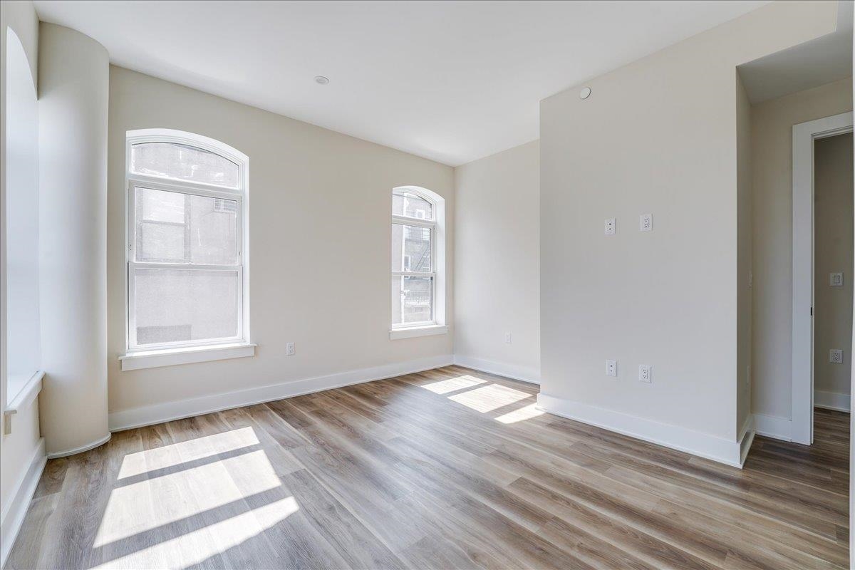 237 Washington Street, Unit 204 Hoboken, NJ 07030 - Photo 15 of 34 an empty room with wooden floor and windows