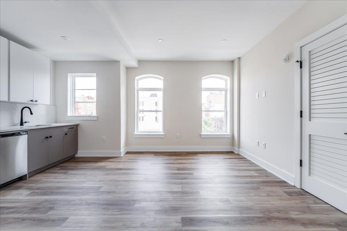 237 Washington Street, Unit 204 Hoboken, NJ 07030 - Photo 18 of 34 a view of an empty room with window and wooden floor