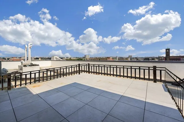a terrace with a bench and city view