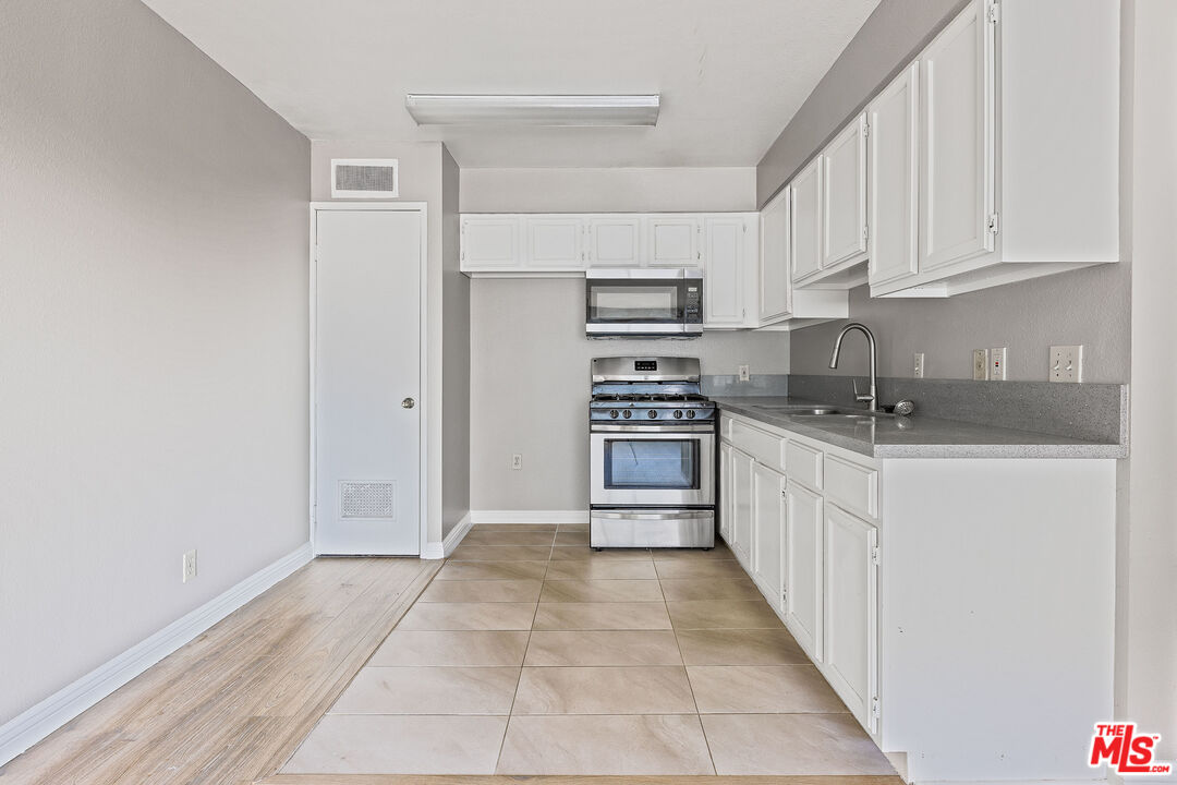 a kitchen with granite countertop a sink and cabinets