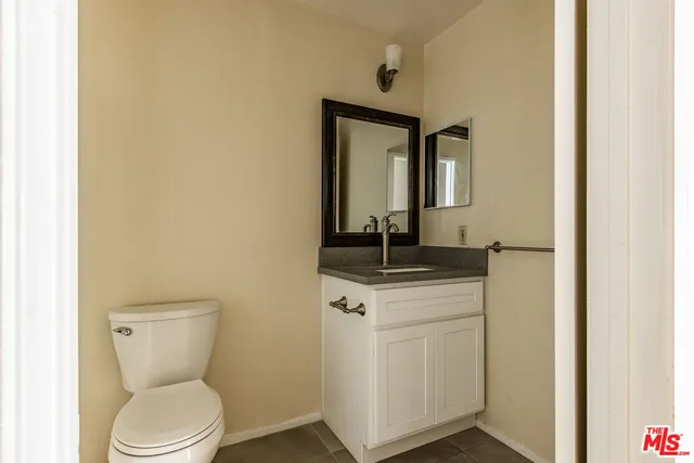 a bathroom with a toilet a sink and mirror