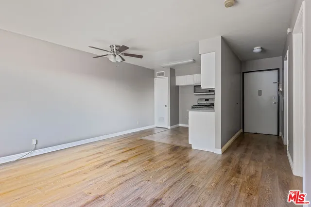 wooden floor in an empty room with a kitchen