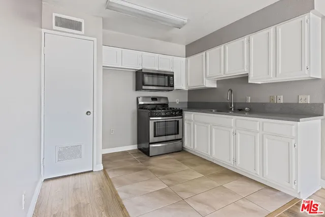 a kitchen with cabinets stainless steel appliances and a counter space