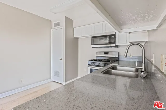 a kitchen with stainless steel appliances a stove and a microwave