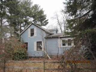 a view of a yard in front of a house with large trees