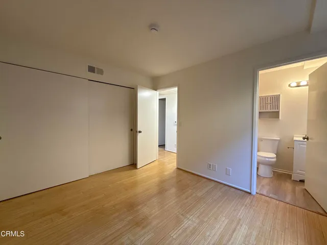 a view of a room with wooden floor and a toilet