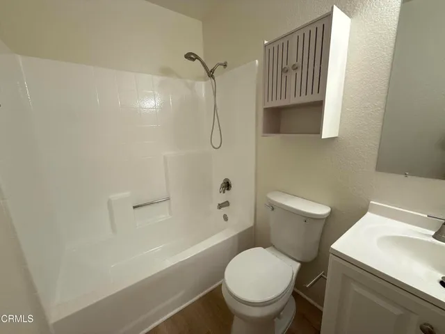 a white toilet sitting next to a bath tub