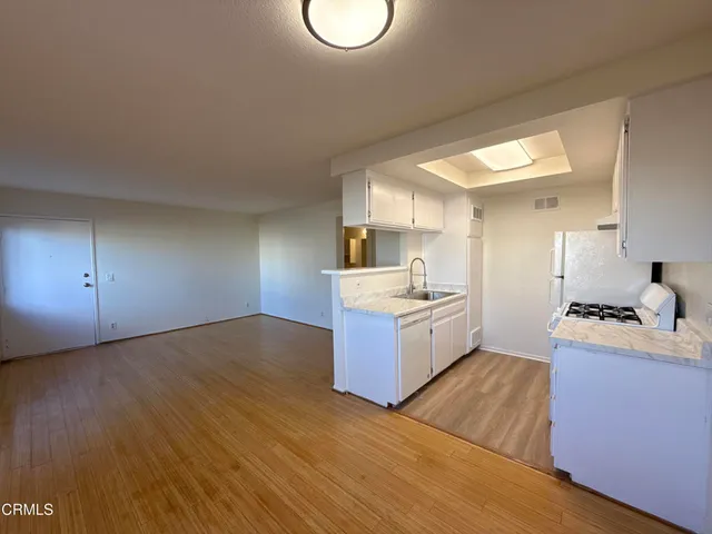 a kitchen with a sink cabinets and wooden floor