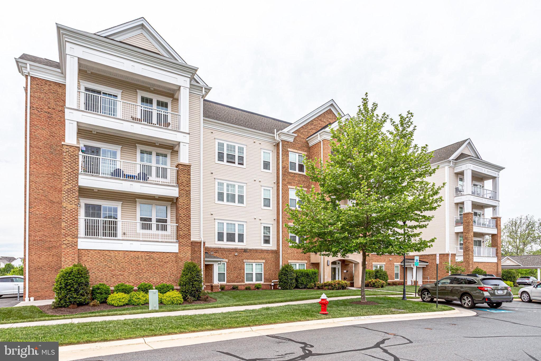 20580 Hope Spring Terrace, Unit 207 Ashburn, VA 20147 - Photo 1 of 61 a front view of a residential apartment building with a yard