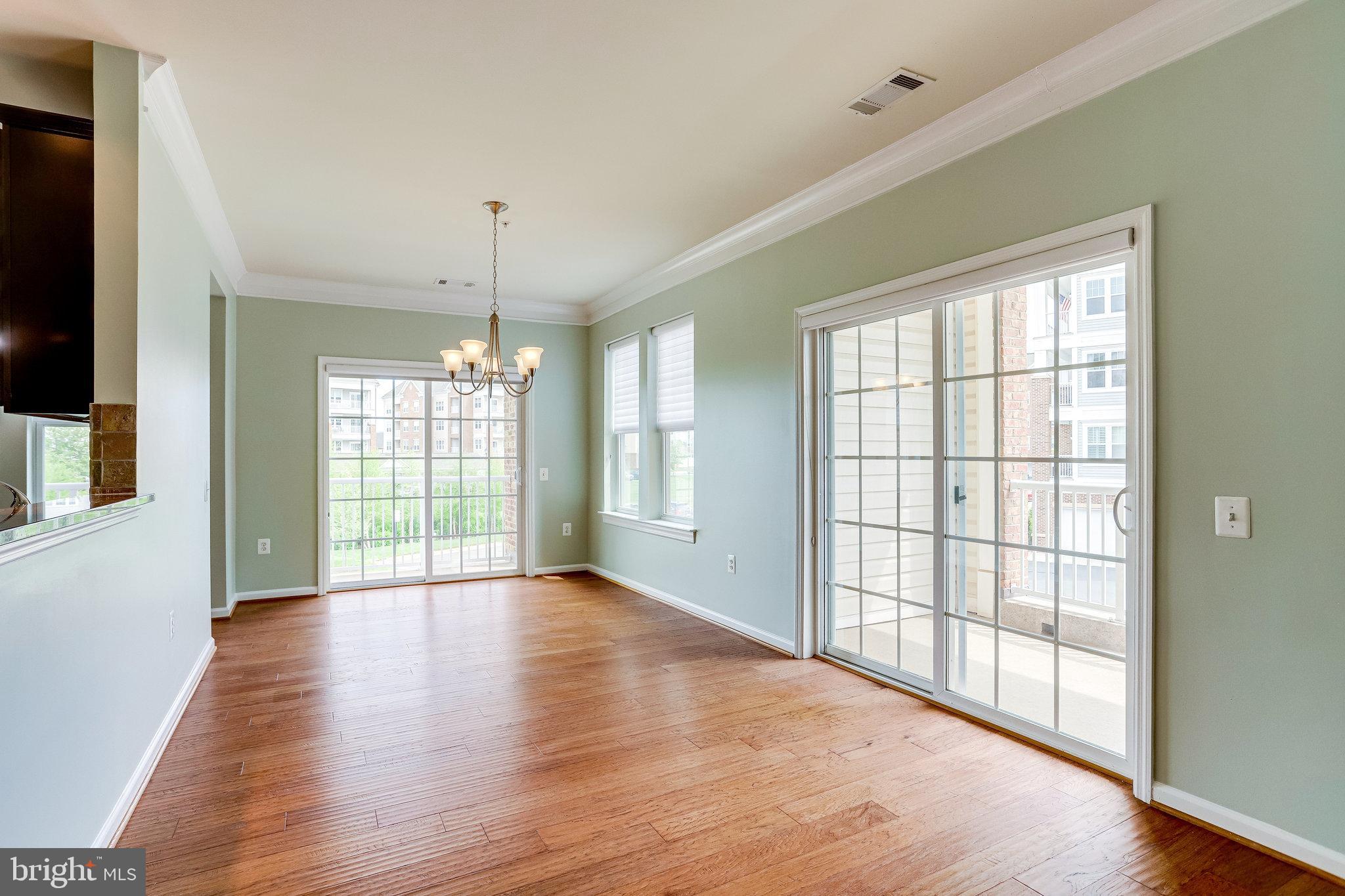 20580 Hope Spring Terrace, Unit 207 Ashburn, VA 20147 - Photo 11 of 61 a view of an empty room with wooden floor and a window