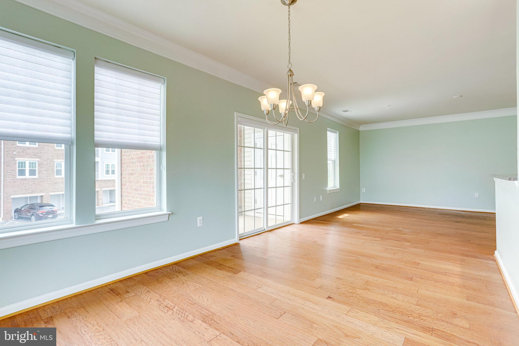 20580 Hope Spring Terrace, Unit 207 Ashburn, VA 20147 - Photo 13 of 61 a view of an empty room with a window and wooden floor