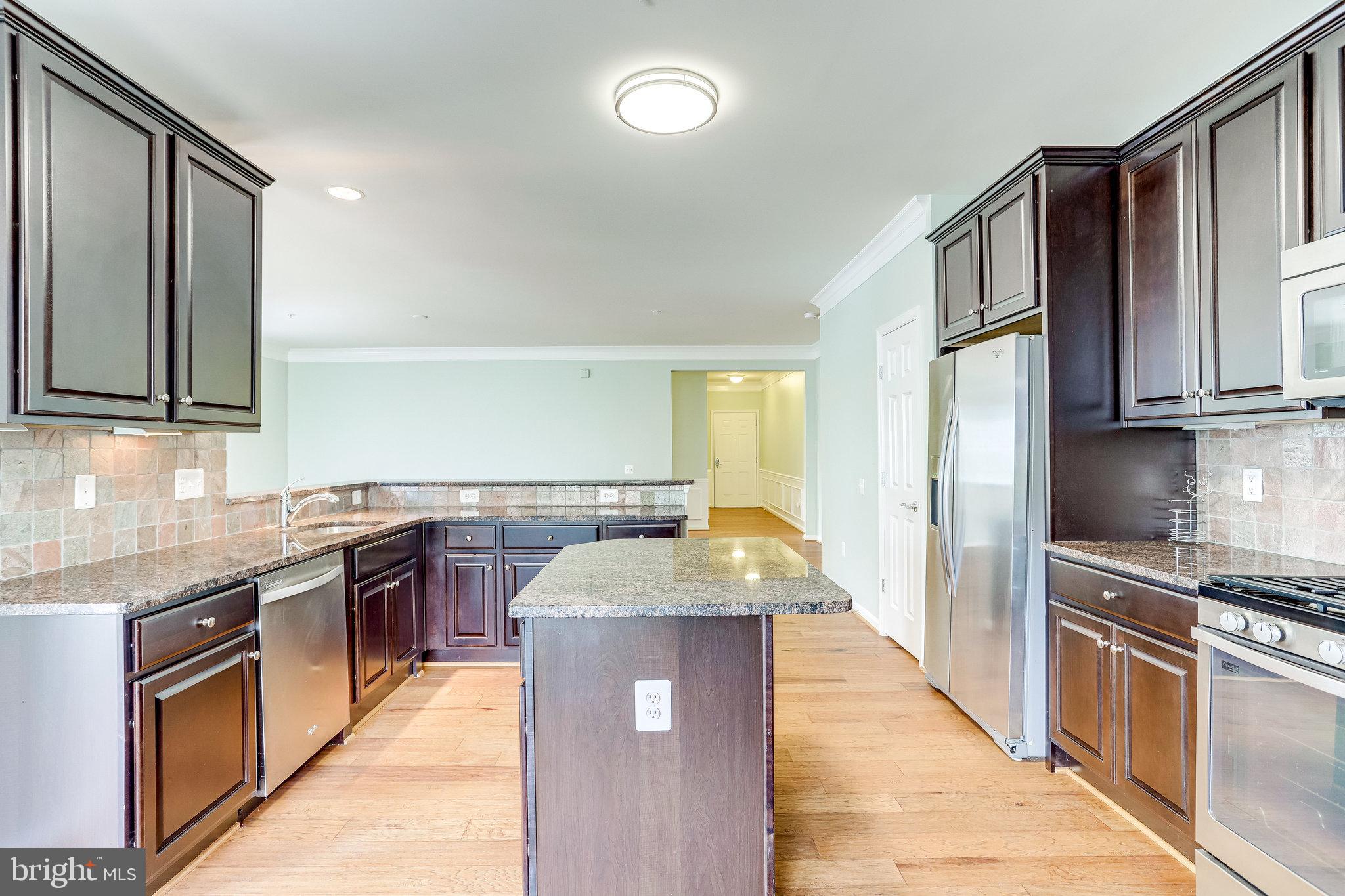 20580 Hope Spring Terrace, Unit 207 Ashburn, VA 20147 - Photo 15 of 61 a kitchen with stainless steel appliances granite countertop a sink stove and refrigerator