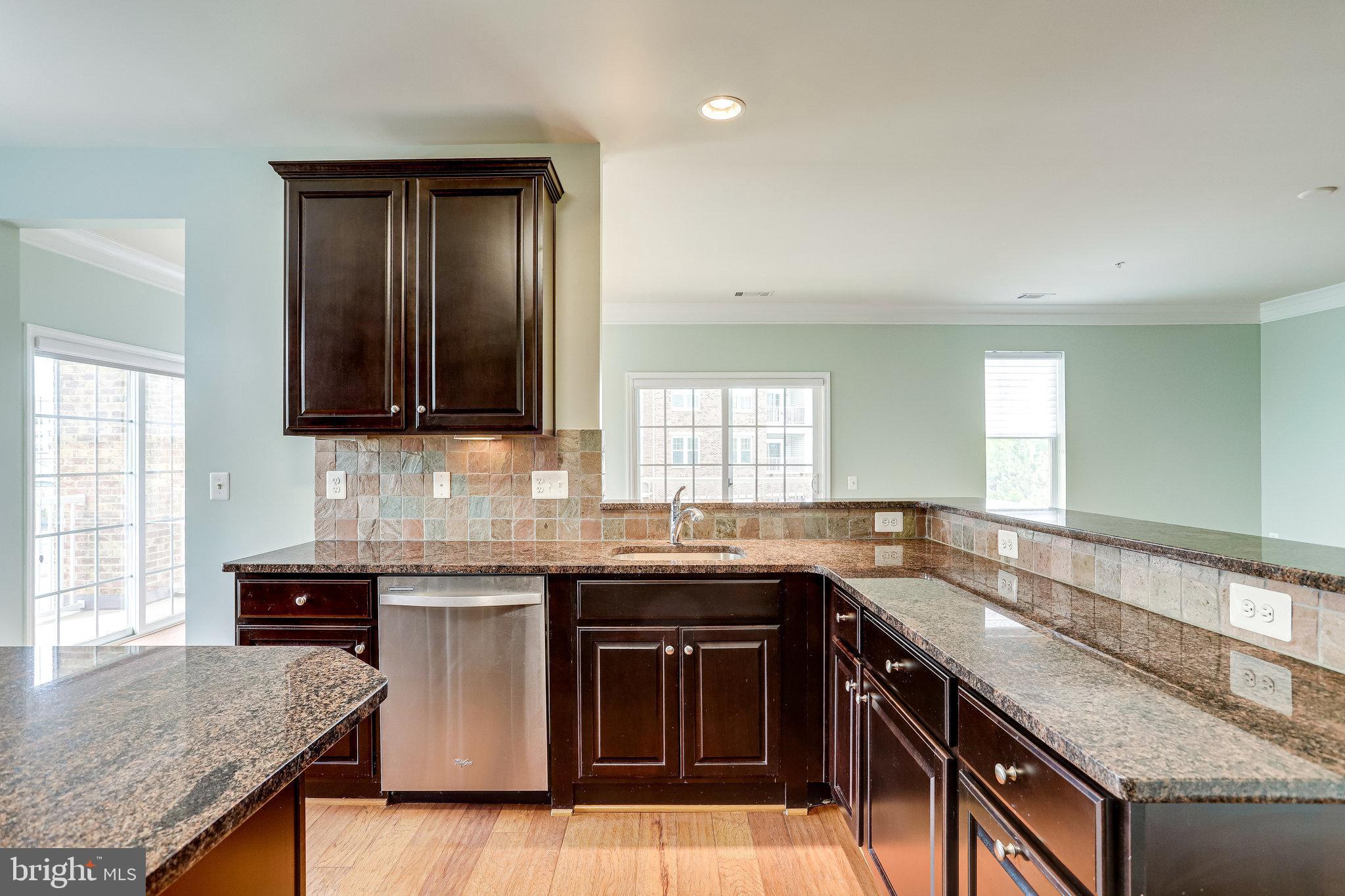 20580 Hope Spring Terrace, Unit 207 Ashburn, VA 20147 - Photo 16 of 61 a kitchen with granite countertop stainless steel appliances a sink stove and cabinets