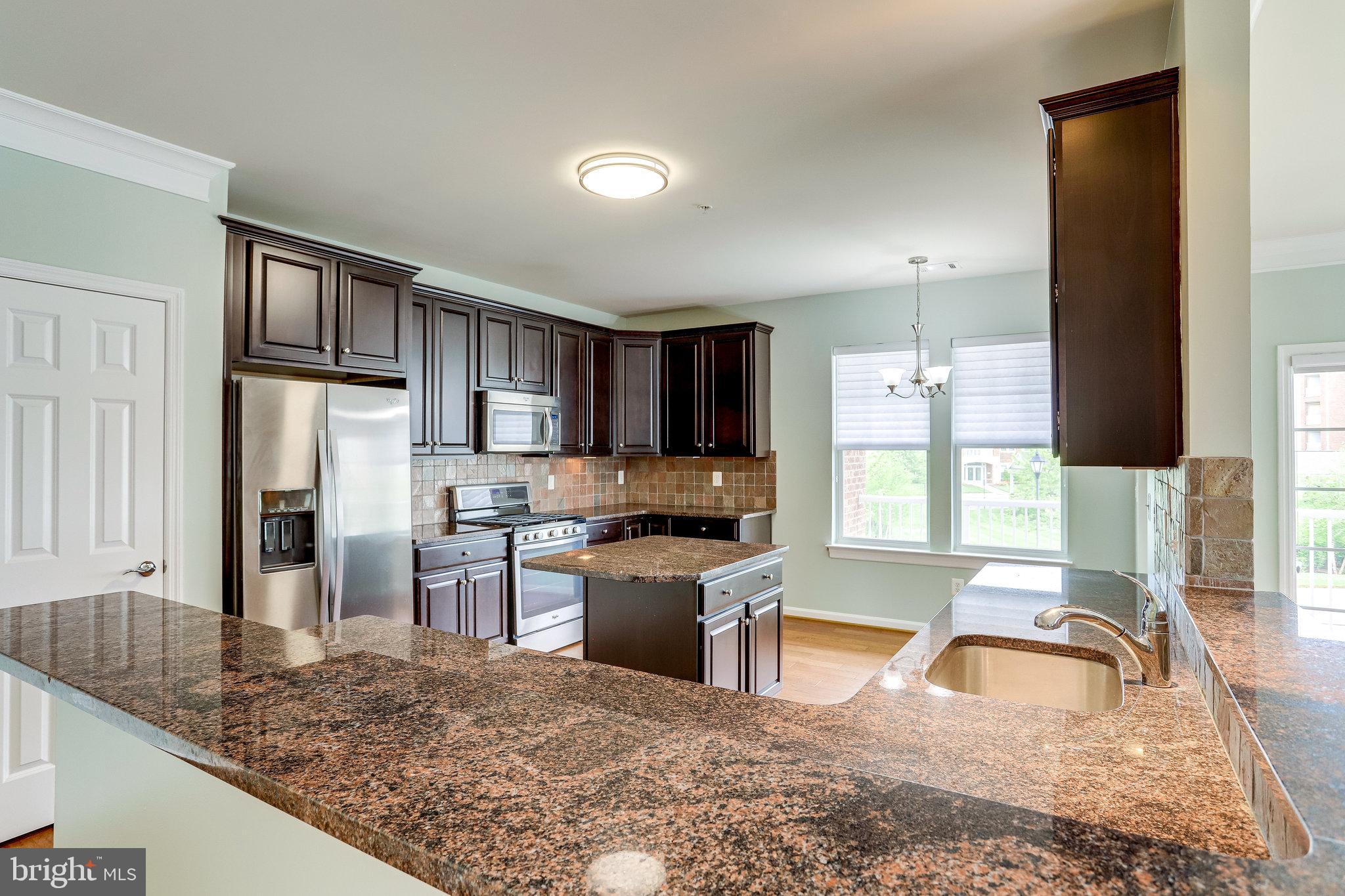 20580 Hope Spring Terrace, Unit 207 Ashburn, VA 20147 - Photo 17 of 61 a kitchen with stainless steel appliances granite countertop a sink stove and refrigerator