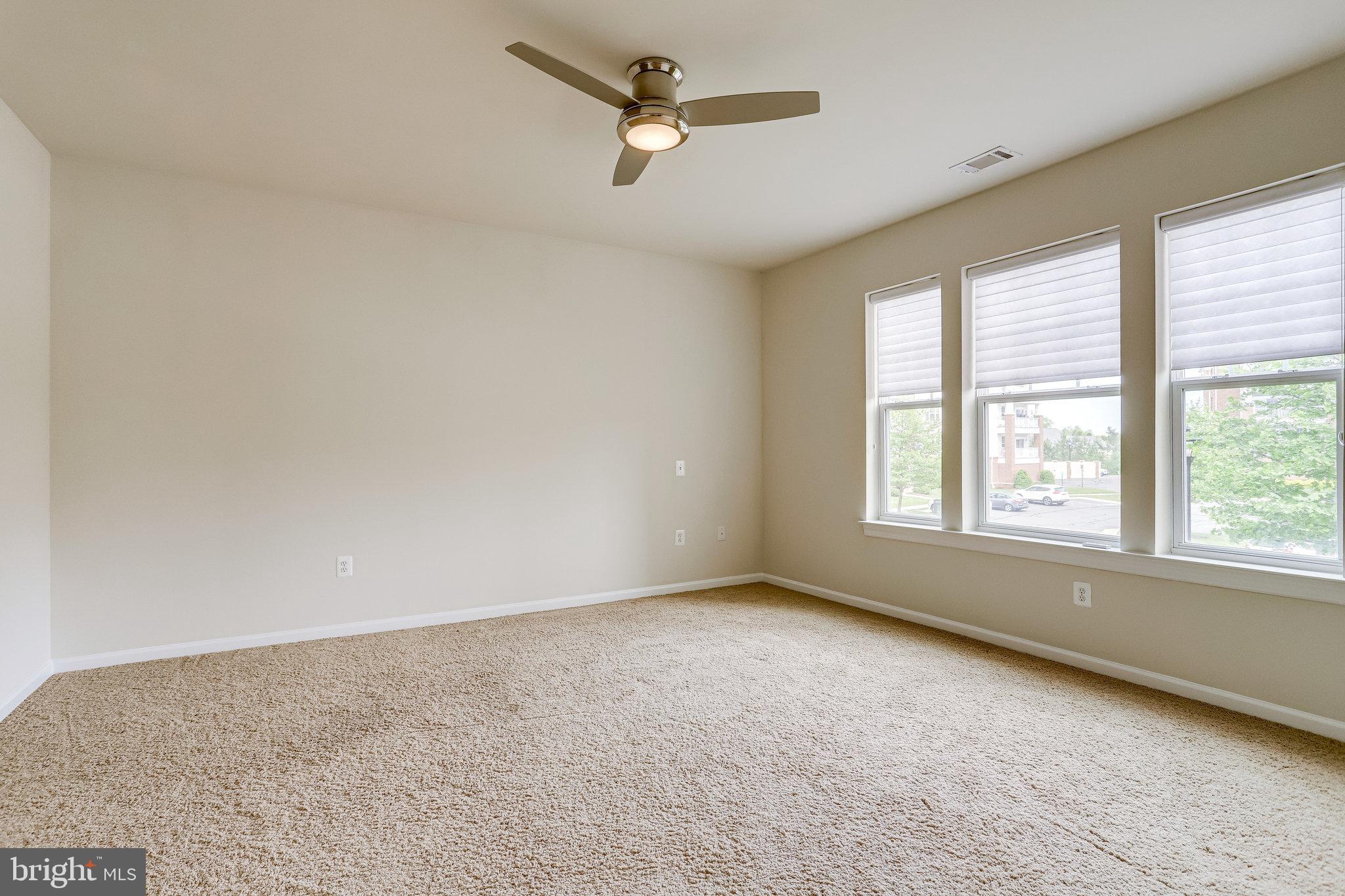 20580 Hope Spring Terrace, Unit 207 Ashburn, VA 20147 - Photo 20 of 61 an empty room with a window and a ceiling fan