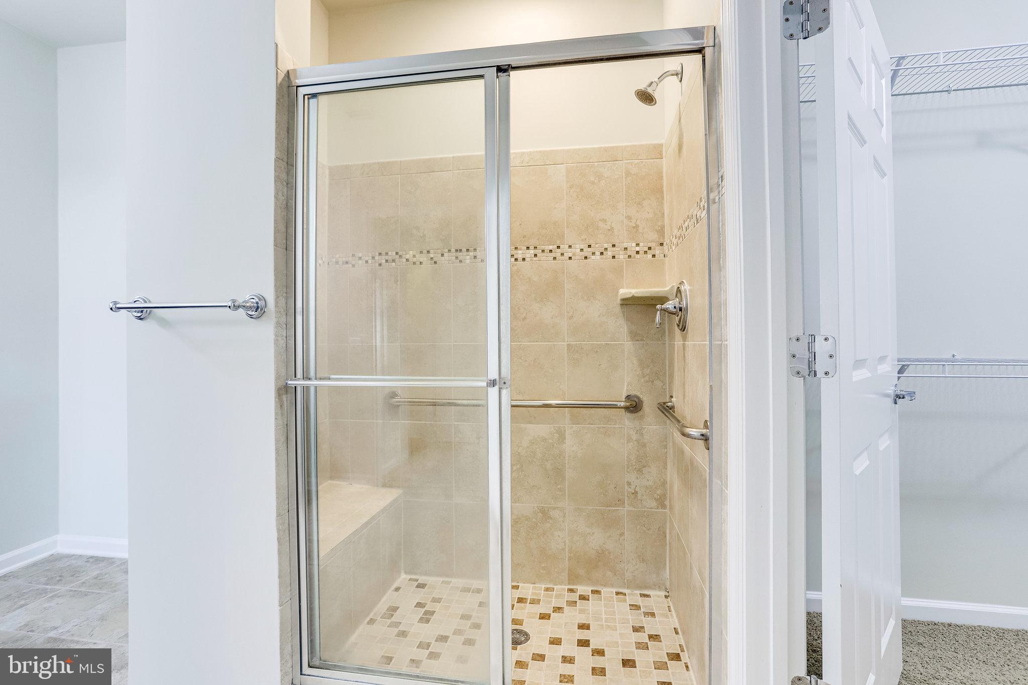 20580 Hope Spring Terrace, Unit 207 Ashburn, VA 20147 - Photo 23 of 61 a bathroom with a glass shower door