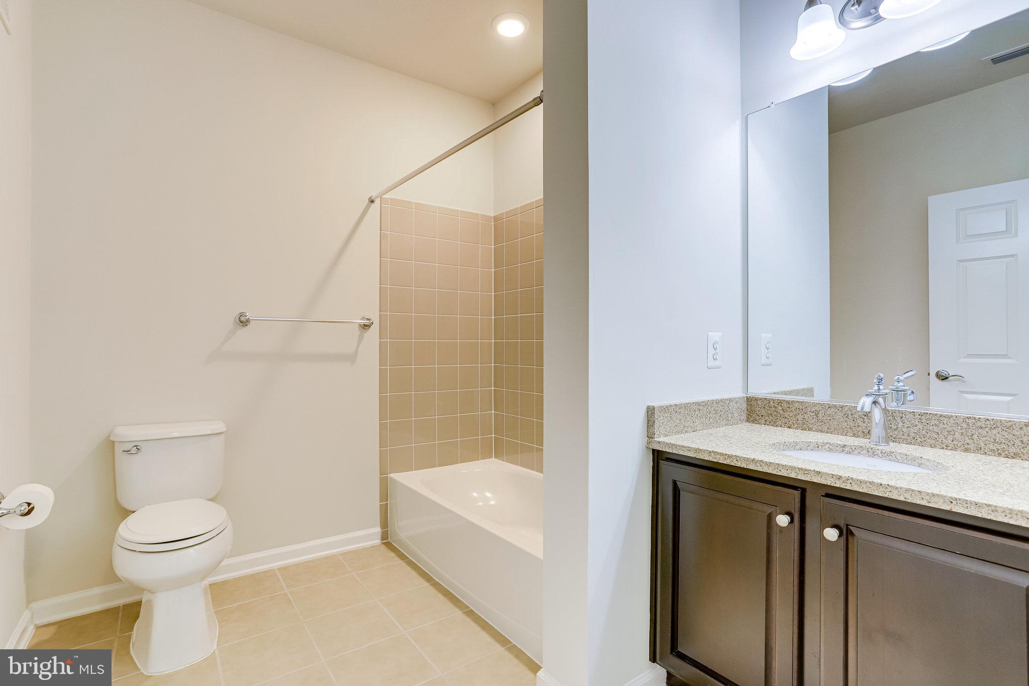 20580 Hope Spring Terrace, Unit 207 Ashburn, VA 20147 - Photo 27 of 61 a bathroom with a sink toilet and shower