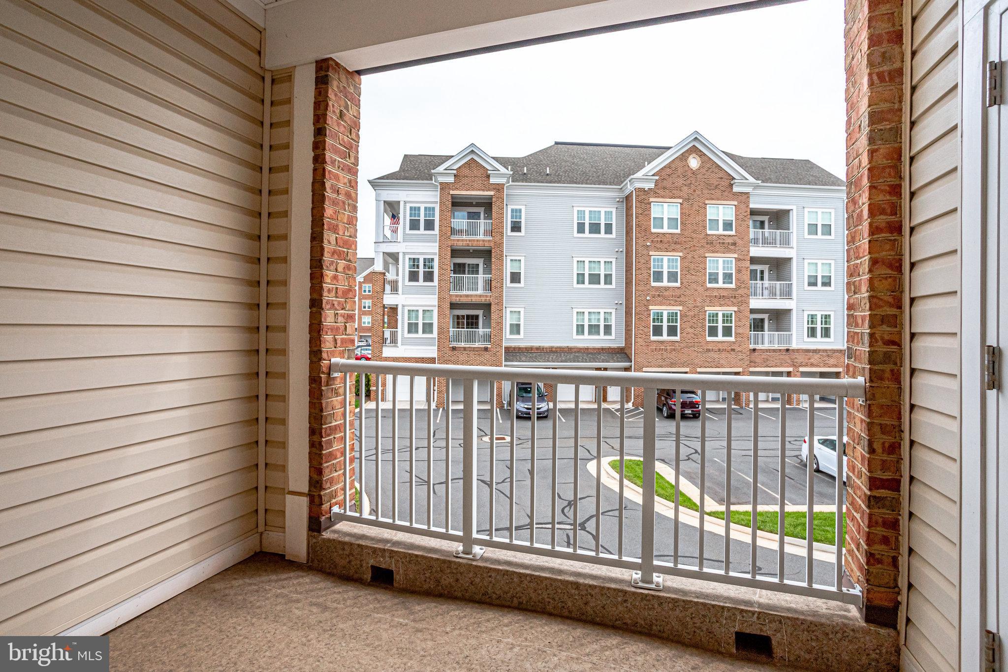 20580 Hope Spring Terrace, Unit 207 Ashburn, VA 20147 - Photo 30 of 61 a view of a brick house with a roof deck