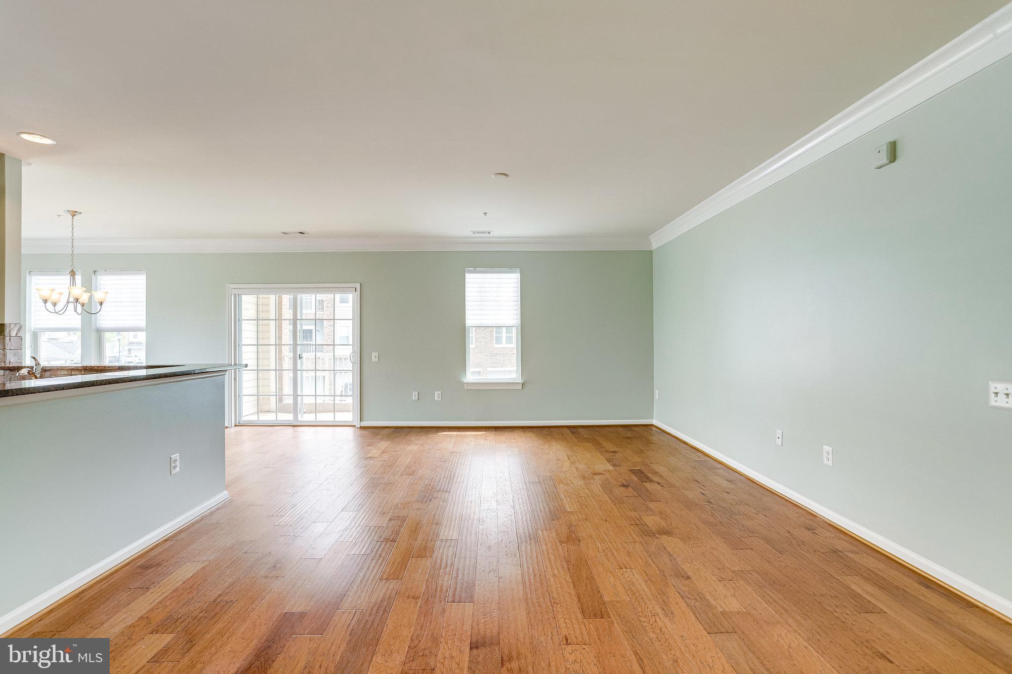 20580 Hope Spring Terrace, Unit 207 Ashburn, VA 20147 - Photo 8 of 61 an empty room with wooden floor and windows