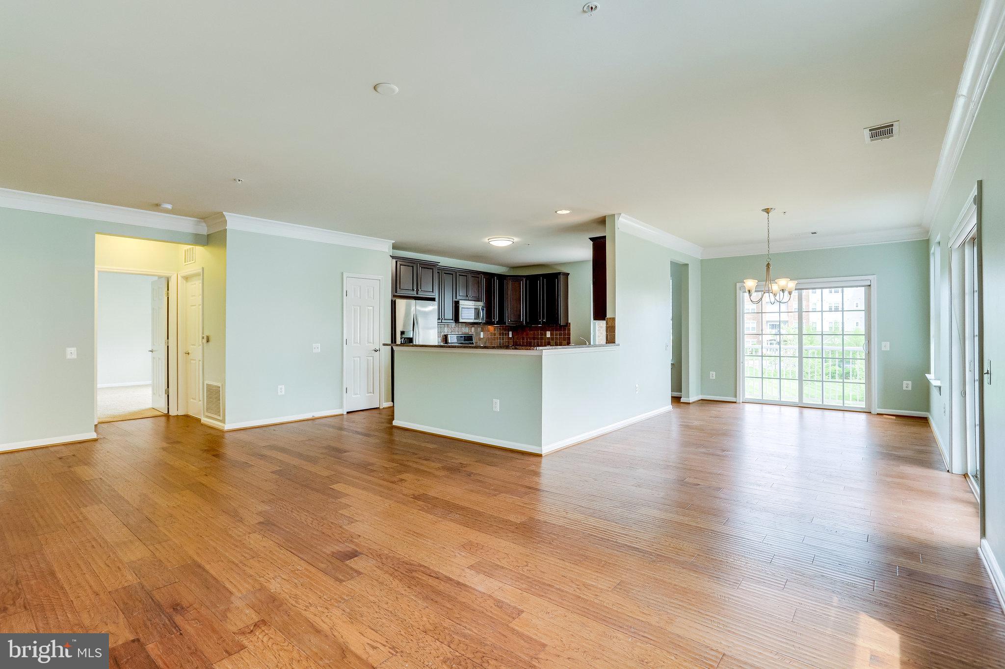 20580 Hope Spring Terrace, Unit 207 Ashburn, VA 20147 - Photo 9 of 61 a view of an empty room with kitchen and window