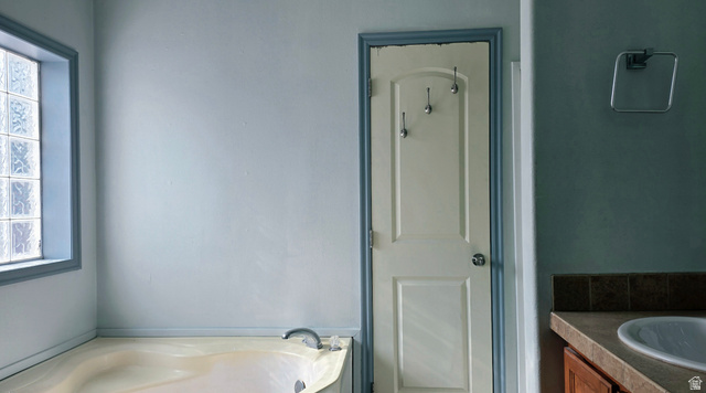 401 West 2000th Street South Vernal, UT 84078 - Photo 10 of 26 Built-in soaking tub with light-colored basin, glass block window, and a single-handle faucet
