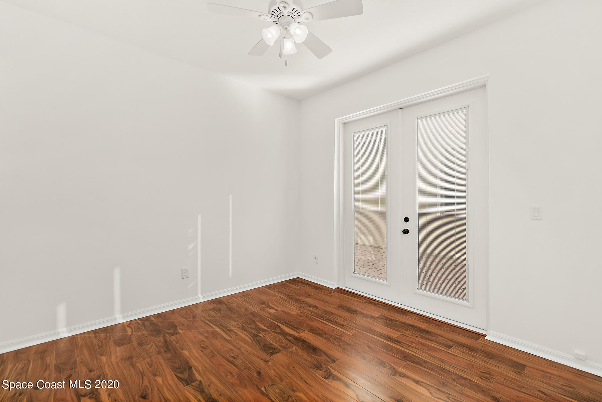 153 Babylon Lane Melbourne, FL 32903 - Photo 26 of 32 an empty room with wooden floor and windows