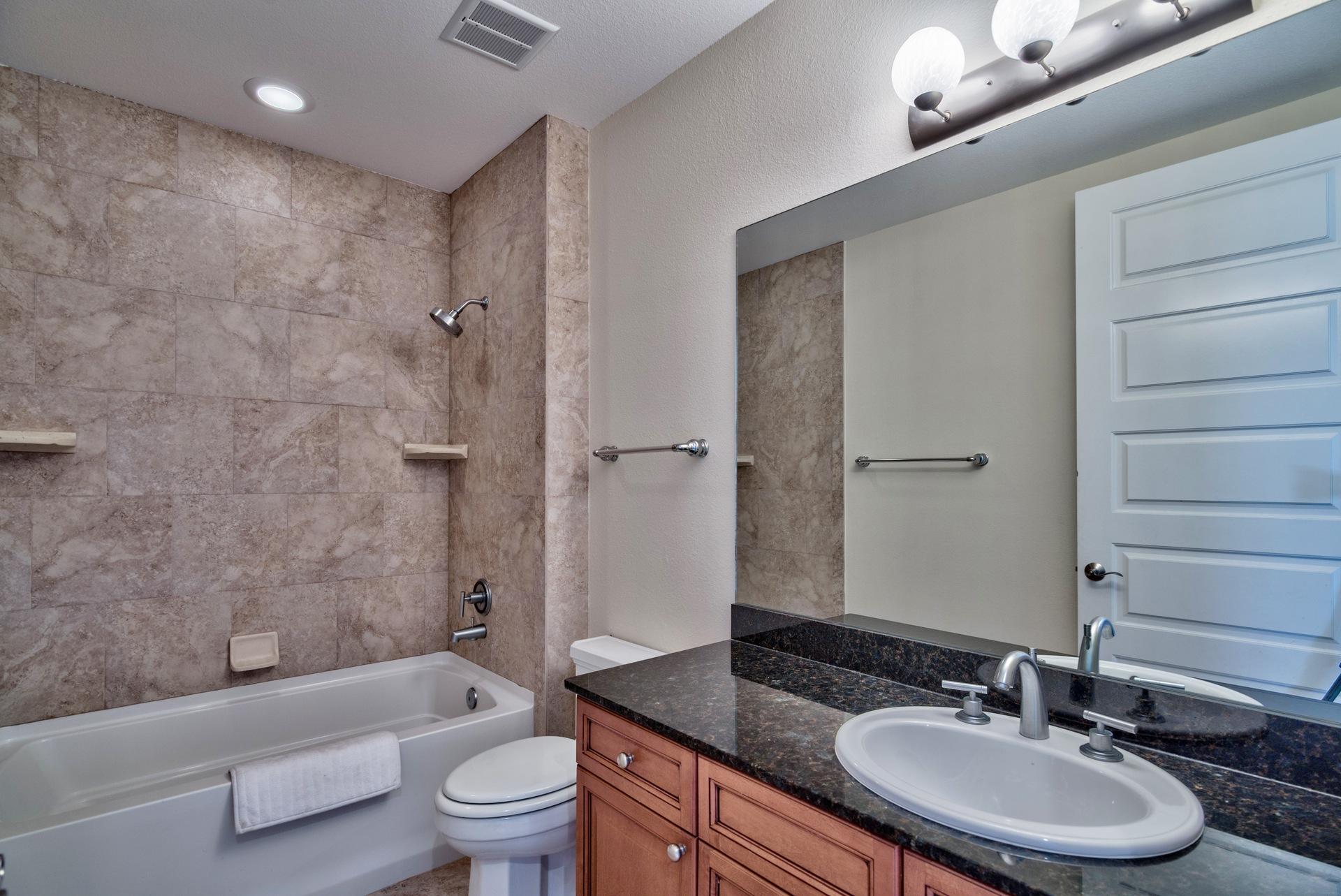 211 Durango Road, Unit 317 Destin, FL 32541 - Photo 26 of 47 a bathroom with a granite countertop sink toilet a mirror and shower