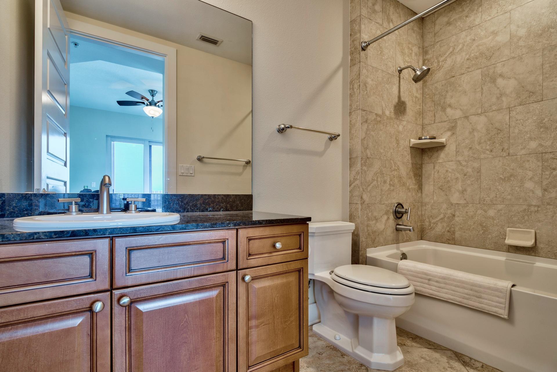 211 Durango Road, Unit 317 Destin, FL 32541 - Photo 29 of 47 a bathroom with a granite countertop toilet sink and mirror