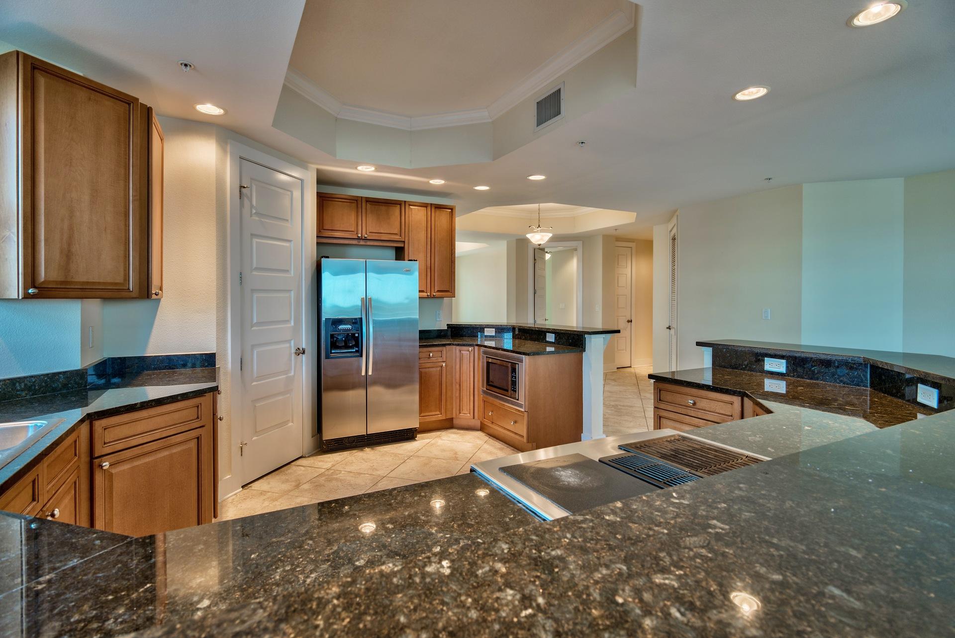 211 Durango Road, Unit 317 Destin, FL 32541 - Photo 10 of 47 a kitchen with stainless steel appliances granite countertop a refrigerator a stove and a sink with wooden floor