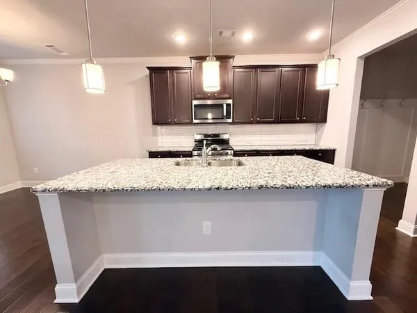 an empty room with wooden floor fireplace and windows
