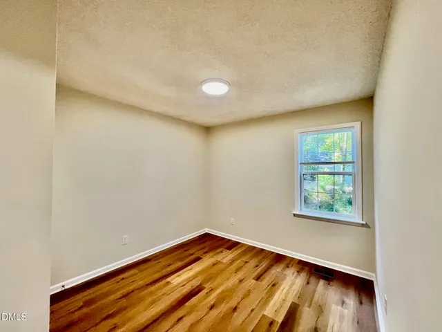 a view of a room with wooden floor and fan
