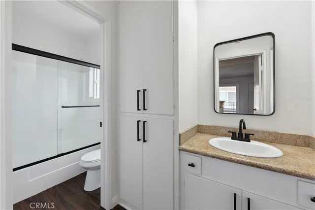 a bathroom with a granite countertop sink toilet and shower