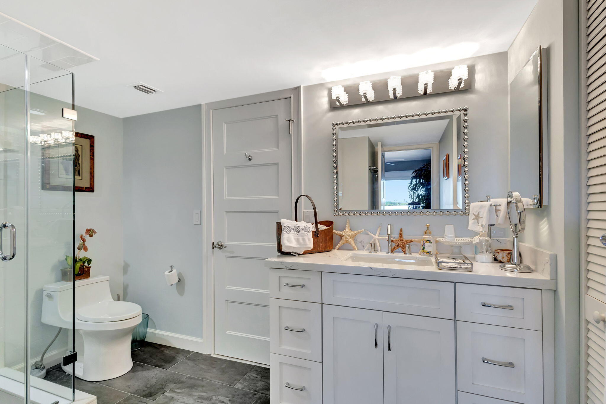 16910 Bay Street, Unit E503 Jupiter, FL 33477 - Photo 8 of 33 a bathroom with a toilet sink and mirror