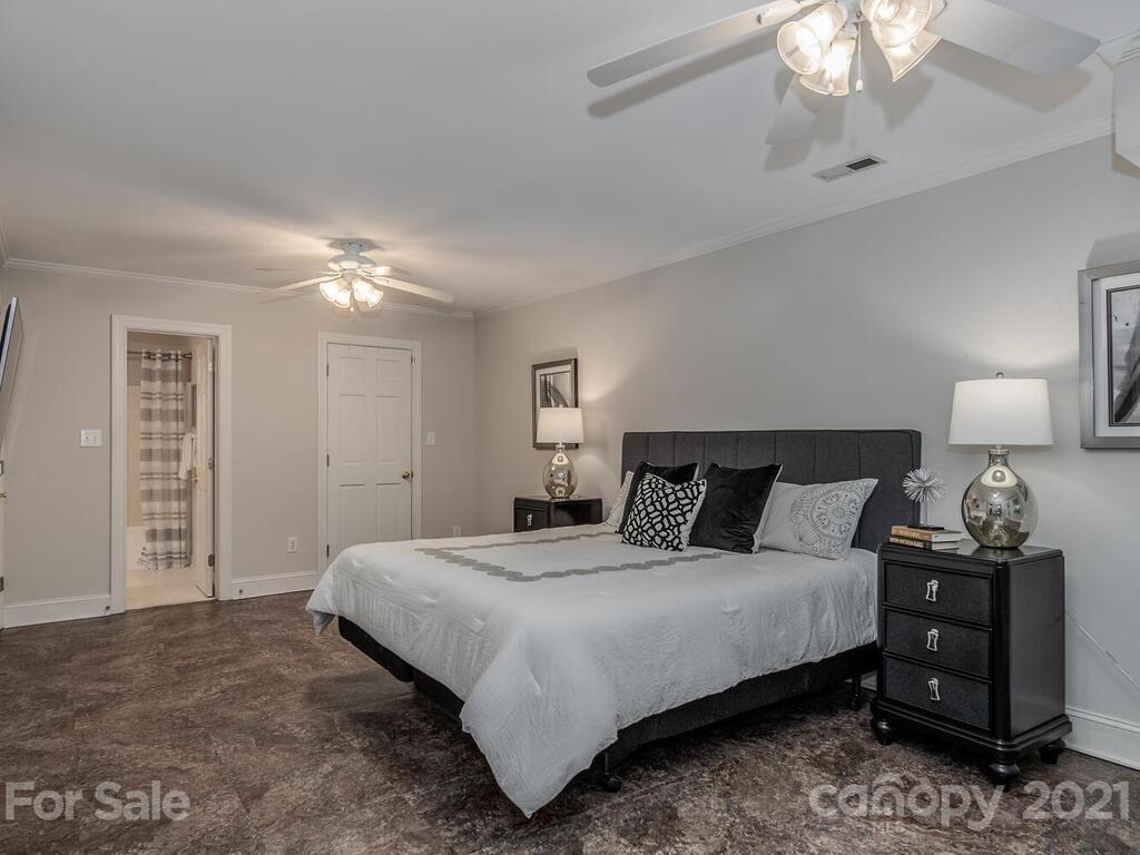 4626 Binfords Ridge Road Charlotte, NC 28226 - Photo 35 of 42 a bedroom with a bed and a lamp on dresser