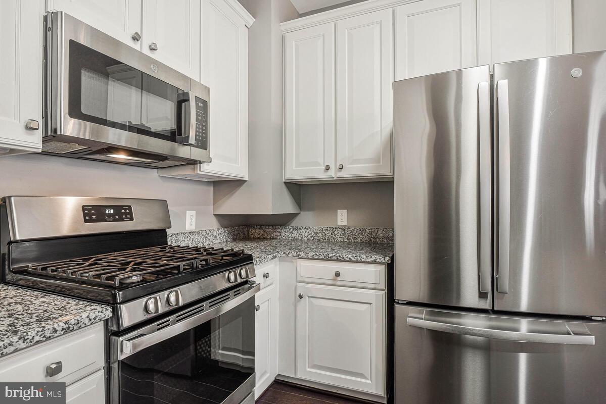 8045 Gatehouse Road, Unit 17 Falls Church, VA 22042 - Photo 12 of 32 a kitchen with stainless steel appliances granite countertop a refrigerator stove top oven and sink