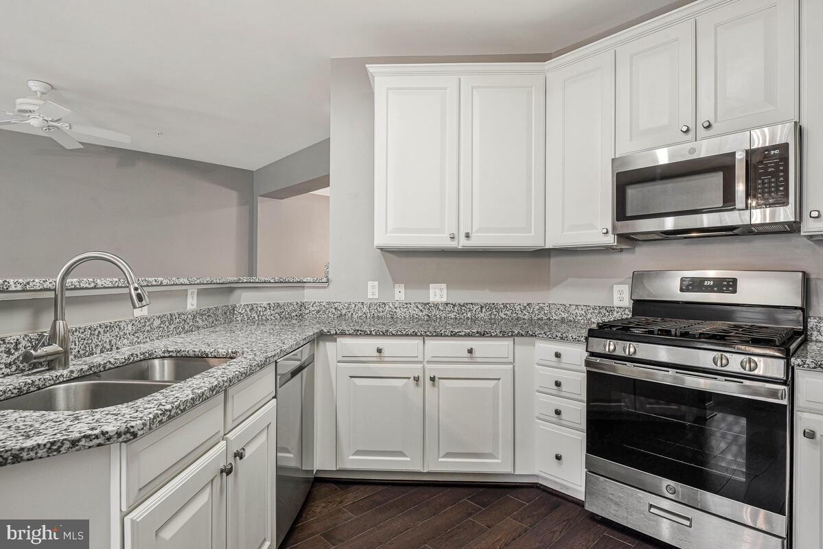 8045 Gatehouse Road, Unit 17 Falls Church, VA 22042 - Photo 13 of 32 a kitchen with white cabinets and stainless steel appliances
