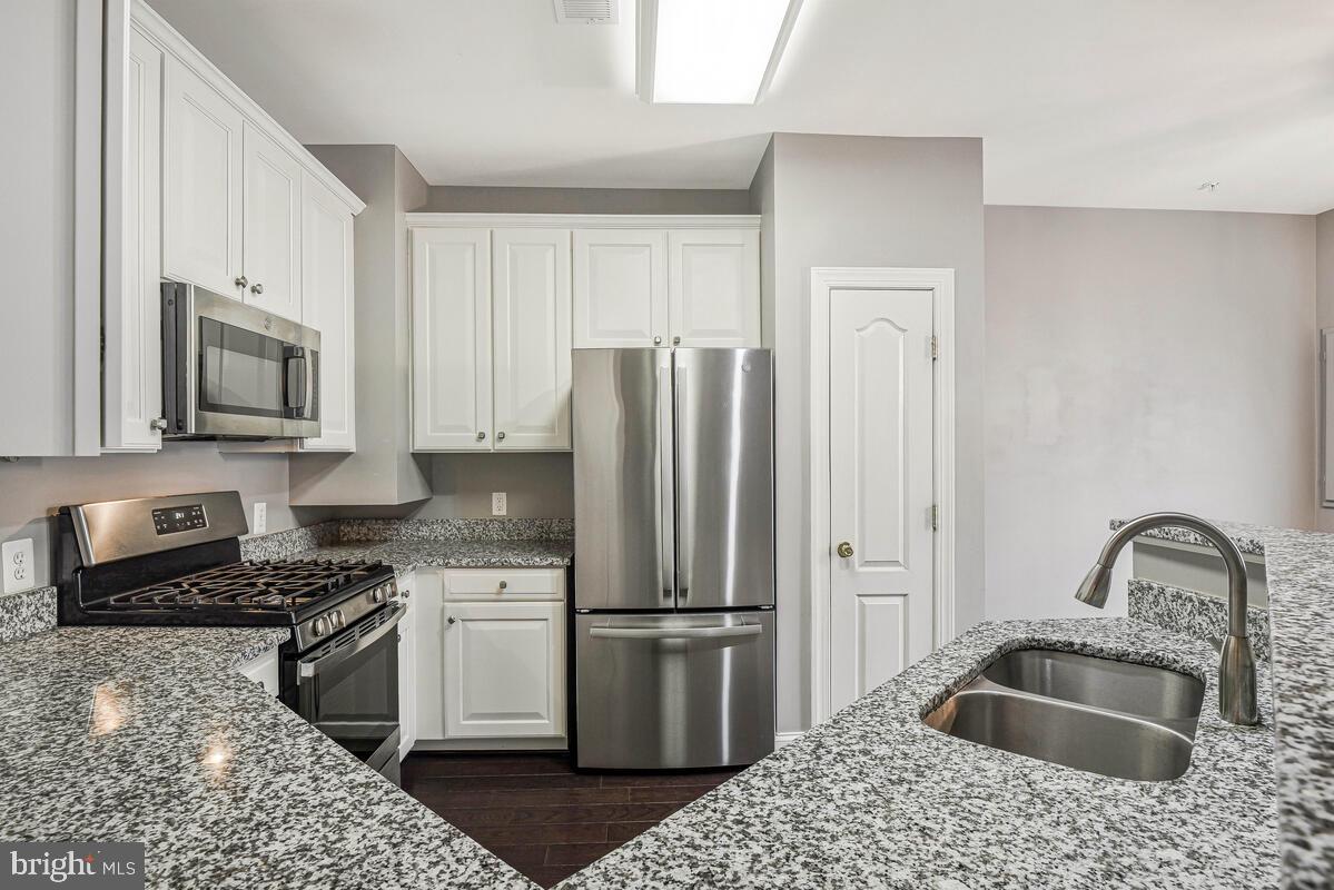 8045 Gatehouse Road, Unit 17 Falls Church, VA 22042 - Photo 14 of 32 a kitchen with stainless steel appliances granite countertop a refrigerator sink and stove