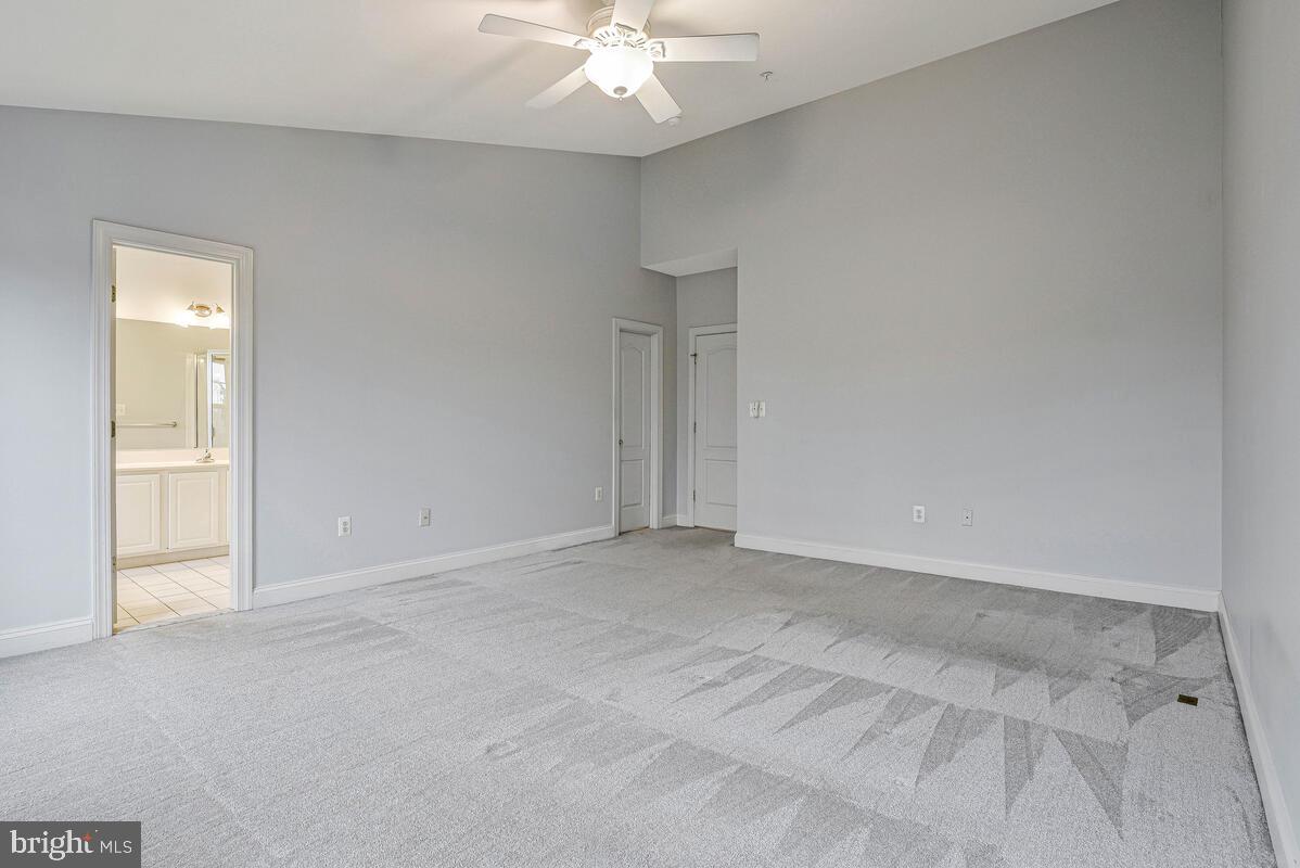 8045 Gatehouse Road, Unit 17 Falls Church, VA 22042 - Photo 24 of 32 an empty room with chandelier fan and windows