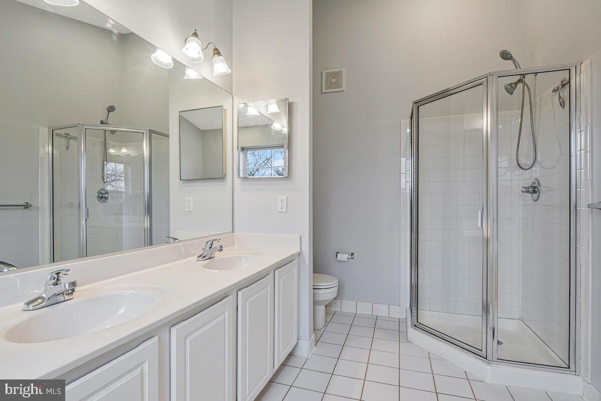8045 Gatehouse Road, Unit 17 Falls Church, VA 22042 - Photo 27 of 32 a bathroom with a double vanity sink mirror and toilet